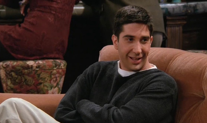 Ross sitting awkwardly on the couch 