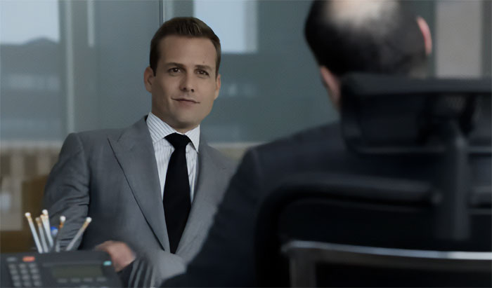 Harvey Specter smiling and talking in meeting room