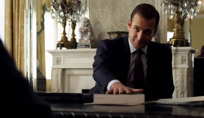 Harvey Specter touching a book