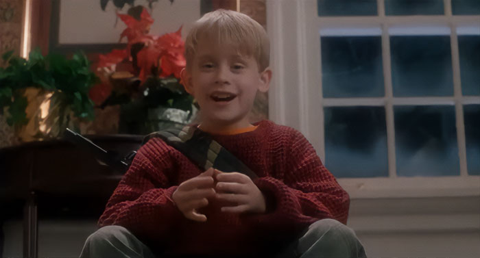 Kevin McCallister sitting and smiling from Home Alone