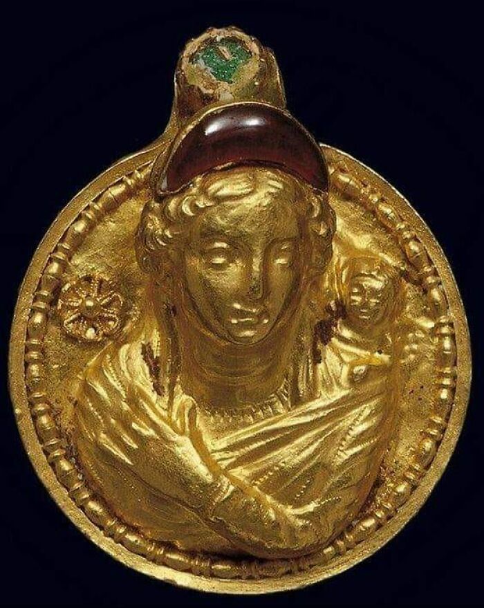 Gold Pendant-Amulet With A Relief Bust Of Aphrodite And Eros (2nd Century Ce), From Alexandria, Egypt. On Forehead Of Goddess Is A Crescent-Shaped Garnet. On Front Of Suspension Loop There Is An Inset Stone Of Green Glass Paste. Louvre Museum