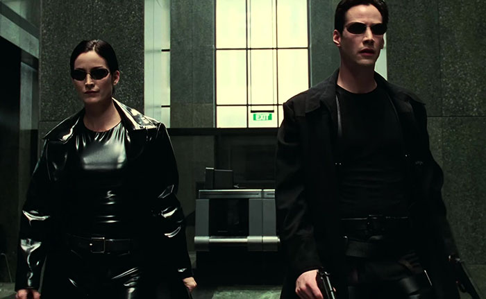 Keanu Reeves wearing black jacket and glasses