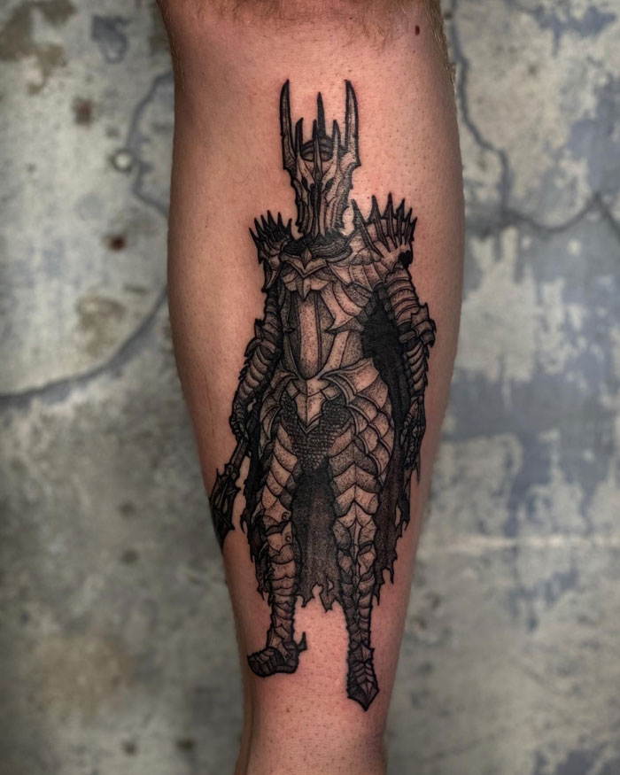 Detailed Lord of the Rings tattoo of dark armored figure on a person's leg, showcasing intricate design elements.