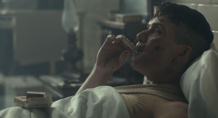 Tommy Shelby smoking a cigarette in a hospital bed 