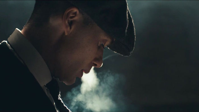 Tommy Shelby smoking while looking down