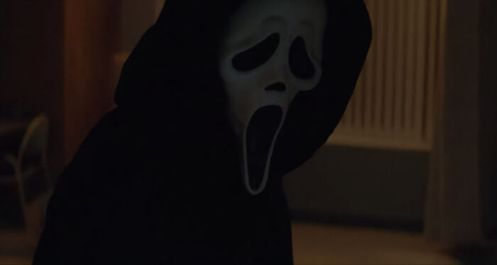 Ghostface looking down in the dark room 
