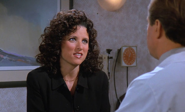 Elaine in a black suit from Seinfeld sharing one of the funniest Seinfeld quotes that sum up everyday life moments.