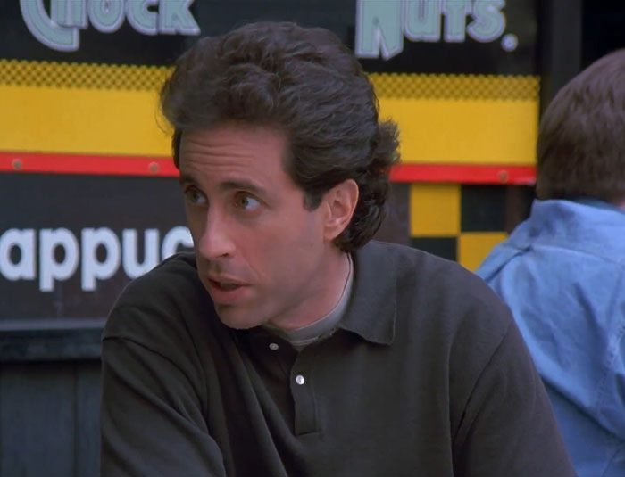 Jerry Seinfeld wearing a black sweater, delivering one of the funniest Seinfeld quotes about everyday life situations.
