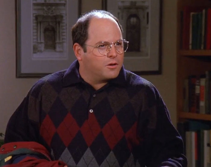 George from Seinfeld wearing a brown red argyle sweater in a scene illustrating funniest Seinfeld quotes about everyday life