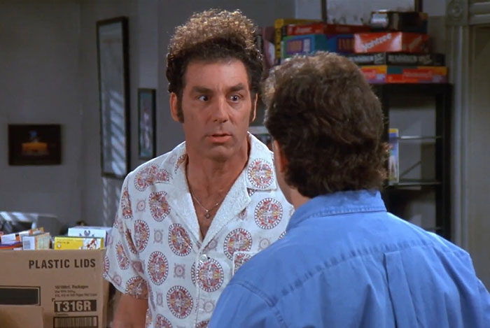 Cosmo Kramer in a white shirt interacting indoors, capturing a moment from the funniest Seinfeld quotes about everyday life.