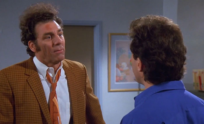 Kramer in a brown suit and white shirt, delivering one of the funniest Seinfeld quotes that sum up everyday life.