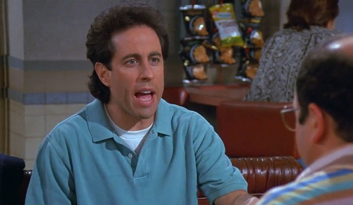 Jerry wearing a blue sweater in a diner scene, representing funniest Seinfeld quotes that sum up everyday life.