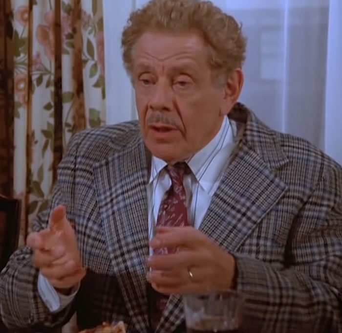 Frank Costanza in a gray suit gesturing during a Seinfeld scene with some of the funniest Seinfeld quotes about life