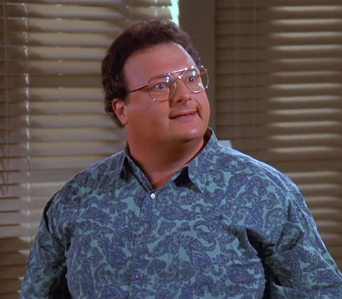 Newman from Seinfeld wearing a blue patterned shirt, representing funniest Seinfeld quotes that sum up everyday life.