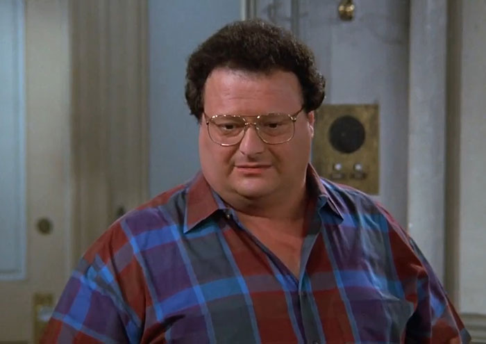 Newman wearing blue and red shirt