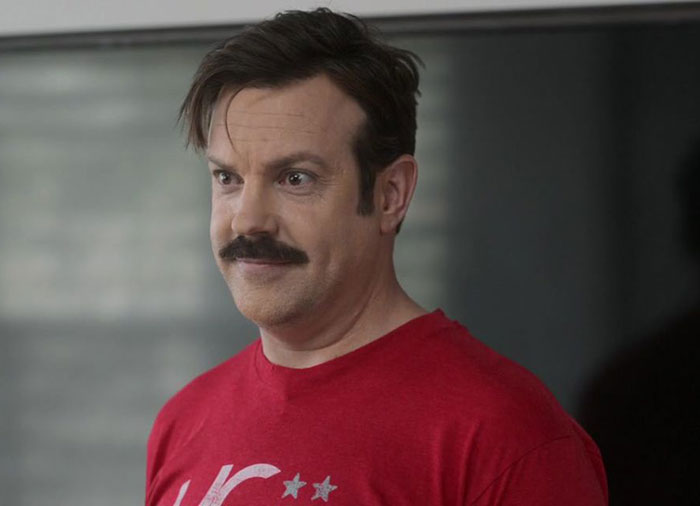 Ted Lasso wearing red shirt