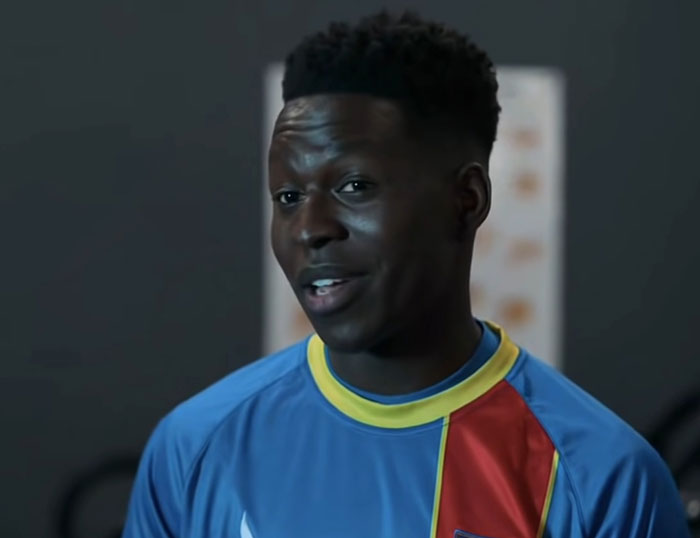 Sam Obisanya wearing blue and red shirt