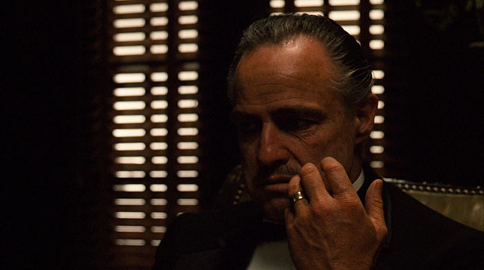 Don Vito Corleone sitting in a chair