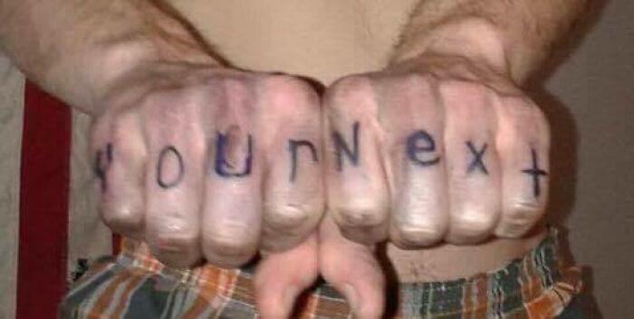 Poor tattoo spelling on knuckles with "Your Next" instead of "You're Next."