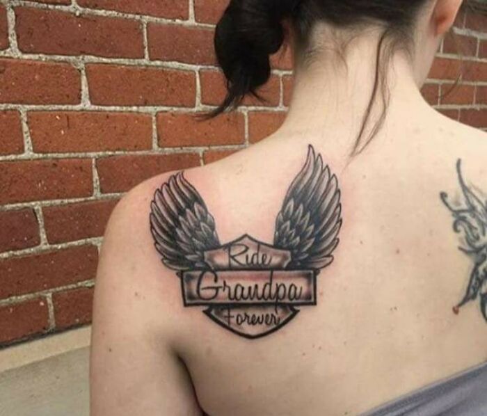Back tattoo with angel wings and text, a classic example of tattoo fails.