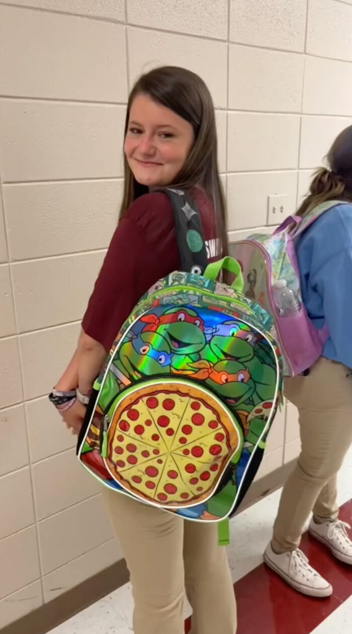High school senior smiling, wearing a colorful kindergarten backpack with Ninja Turtles and pizza design. High school senior smiling, wearing a colorful kindergarten backpack with Ninja Turtles and pizza design.