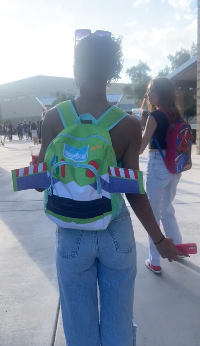 High school senior with a colorful kindergarten backpack, walking in the school courtyard. High school senior with a colorful kindergarten backpack, walking in the school courtyard.