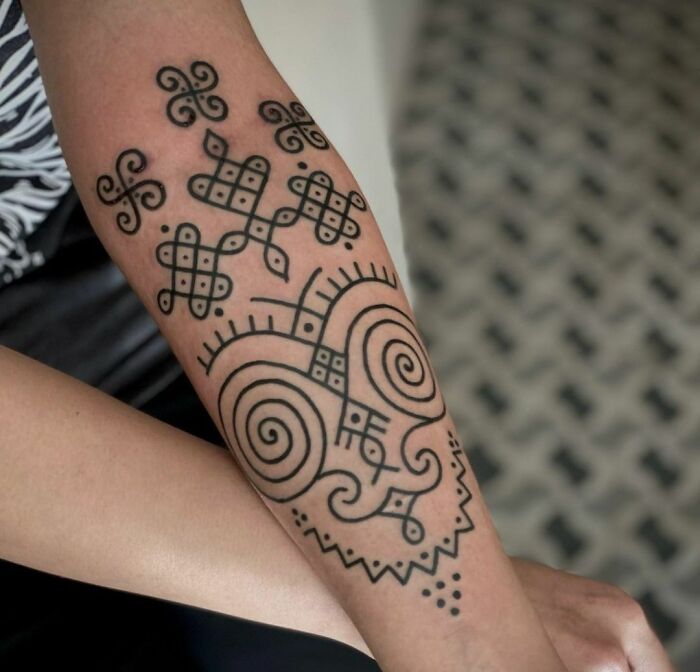 Tribal tattoo design on a forearm featuring intricate patterns and spirals.