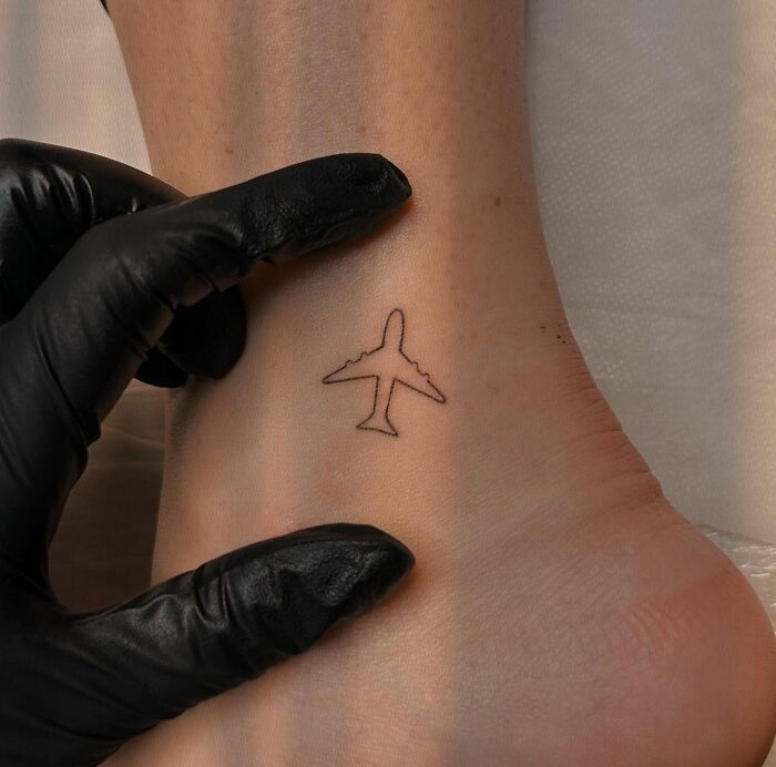 Minimalistic airplane ankle tattoo