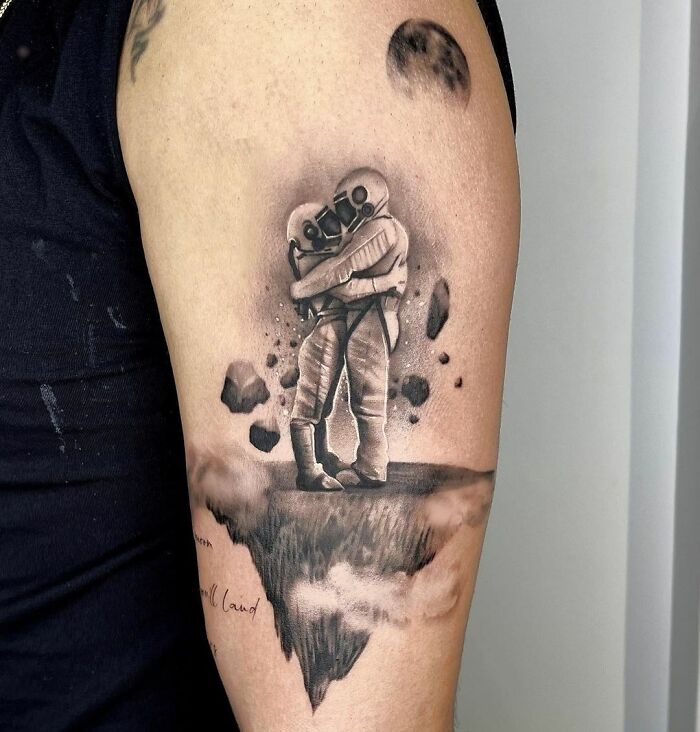 Two astronauts kissing arm tattoo