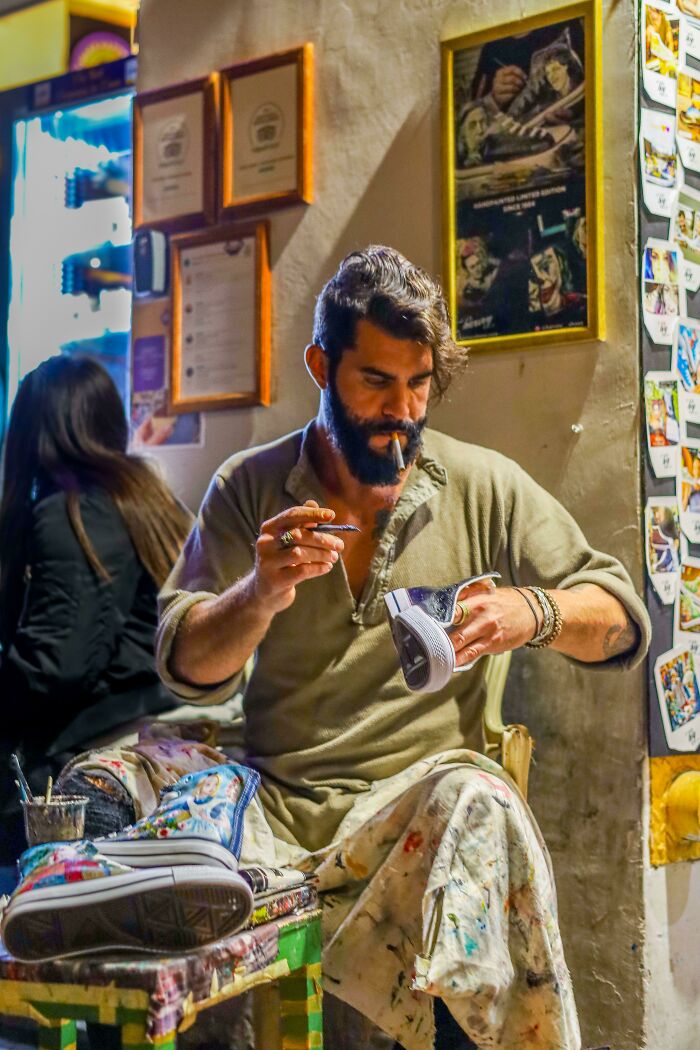 Hombre pintando zapatos en una calle de Roma