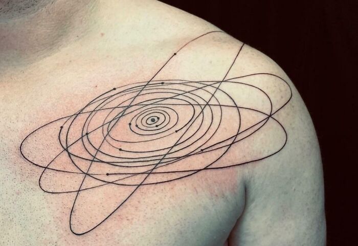 Solar system orbits stylized chest tattoo