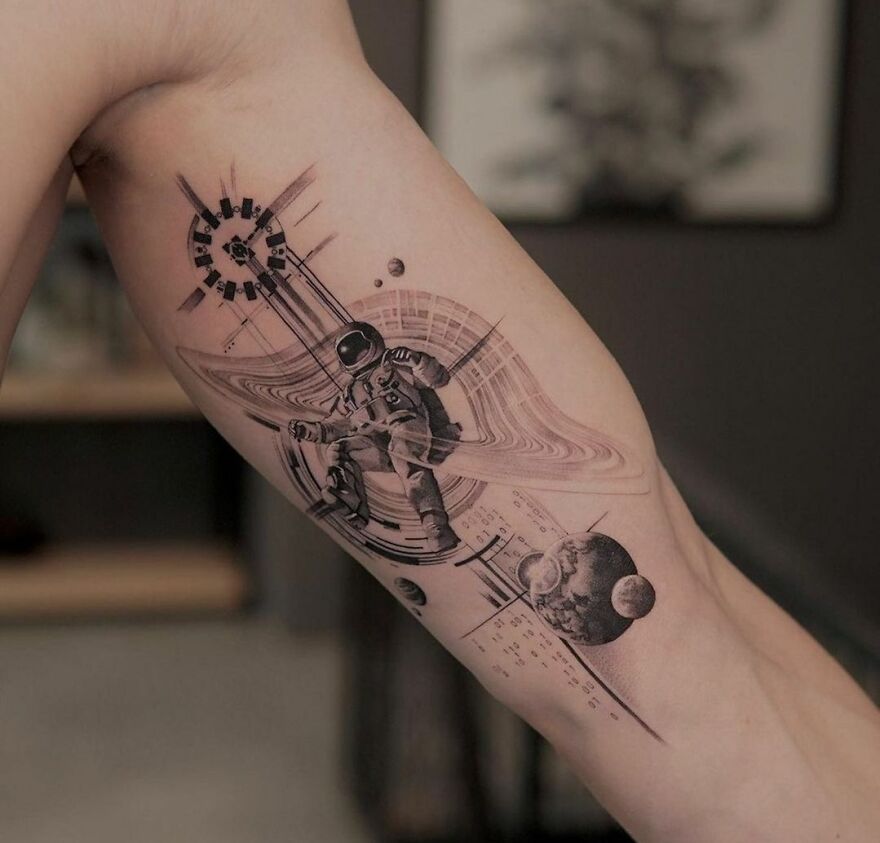 Astronaut in space with abstract elements arm tattoo