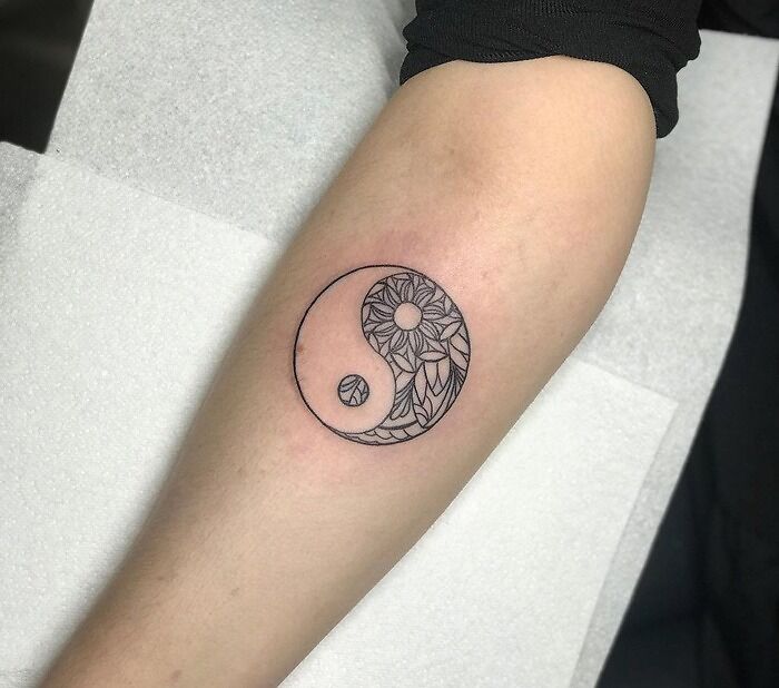 Yin yang symbol arm tattoo 