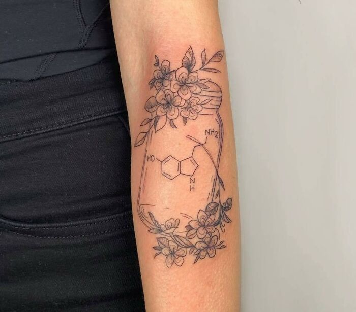 Molecules, glass jar and flowers tattoo on arm