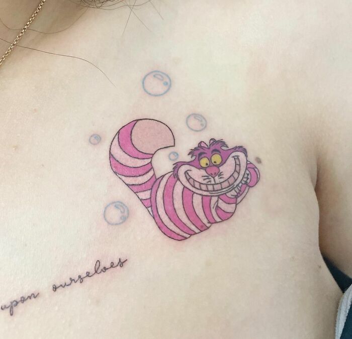 Cheshire Cat with small soap bubbles collarbone tattoo
