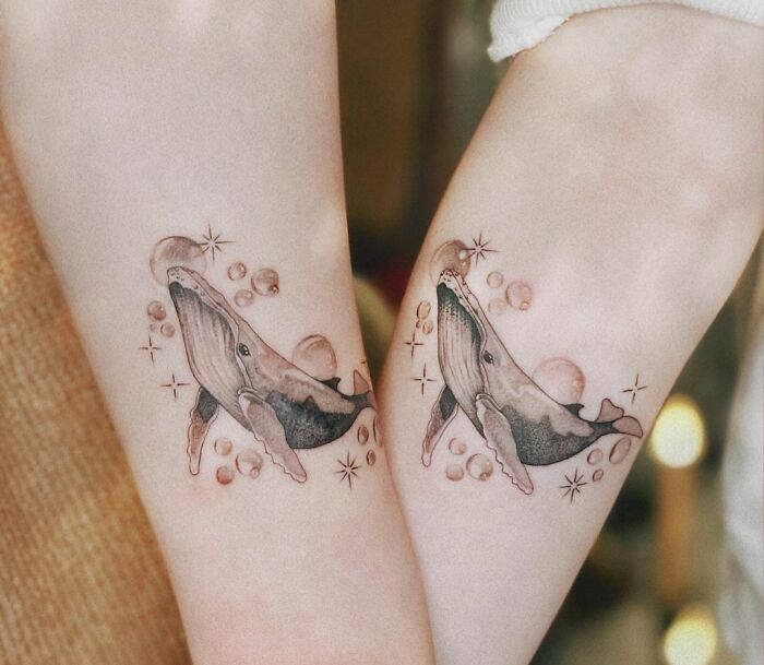Matching whale with soap bubbles arm tattoos