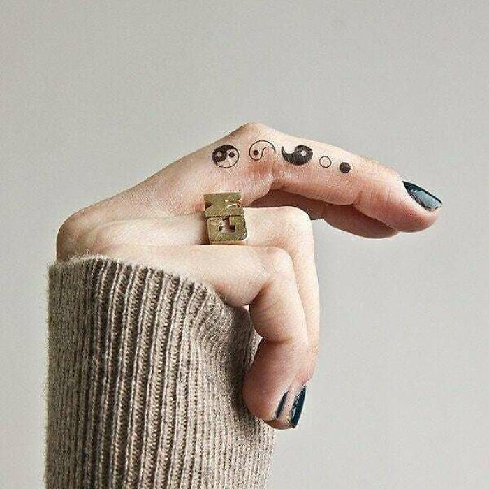 Yin yang symbols finger tattoo 