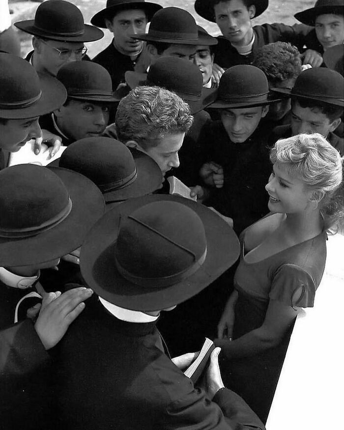La actriz italiana Marisa Allasio rodeada de jóvenes sacerdotes, 1957