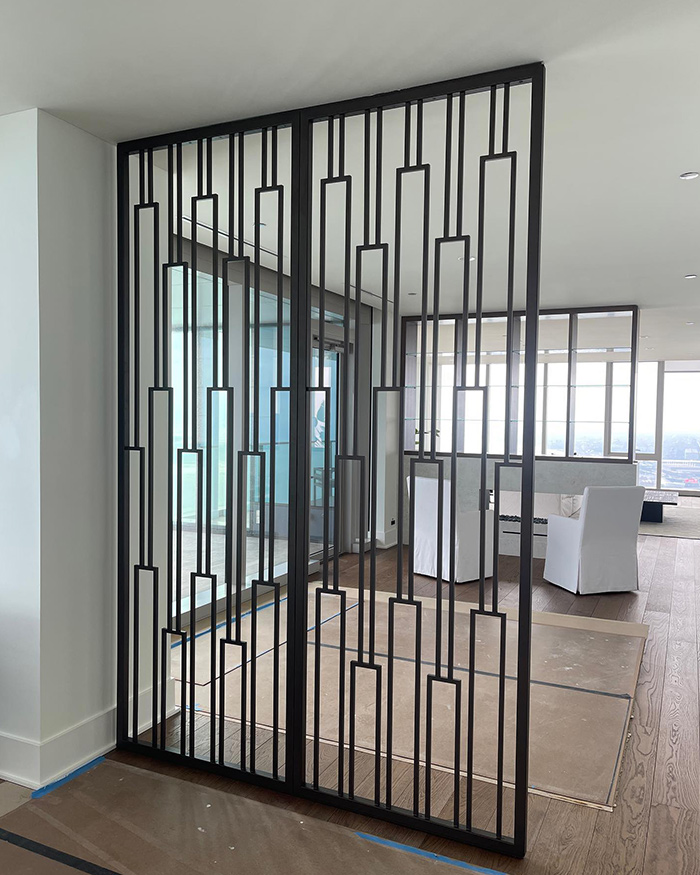 A custom-made metal room divider fabricated from cold-finished bar with bronze powder coat in a spacious interior