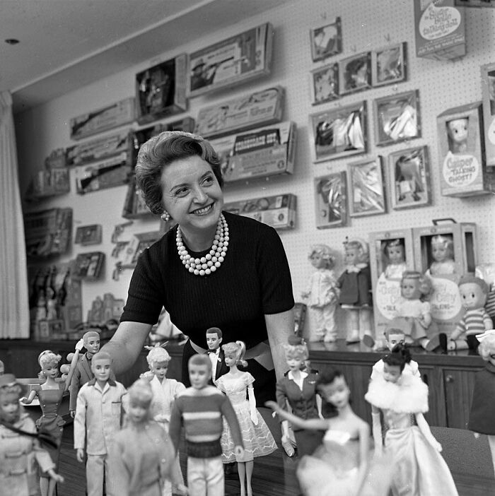  Ruth Handler, executive of Mattel Toy company, posing with collection of Barbie dolls, 1961
