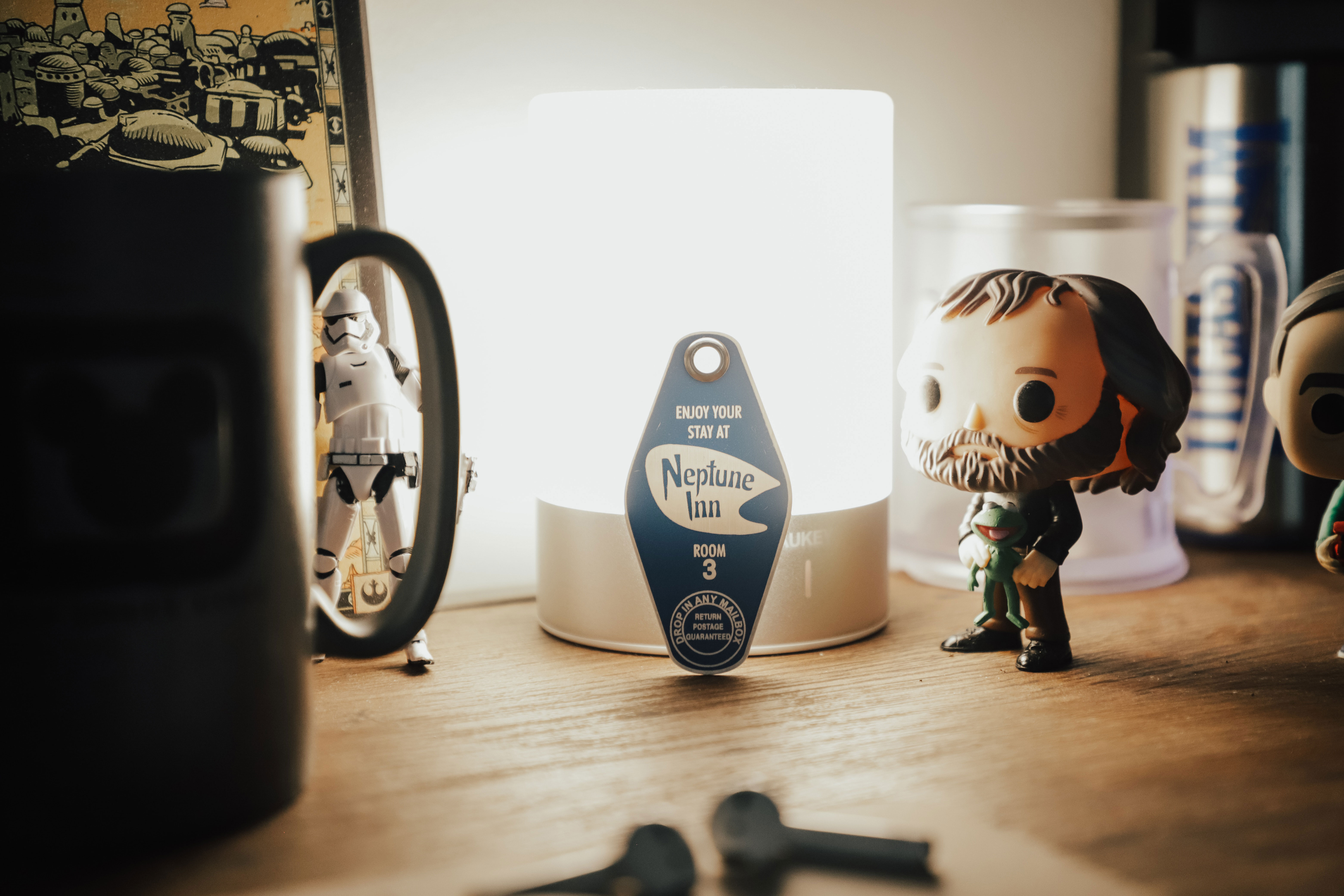A Star Wars Funko Pop displayed on a wooden table next to a light and other Star Wars merchandise
