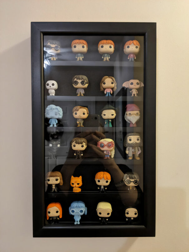 Funko Pop collection displayed on glass cabinet