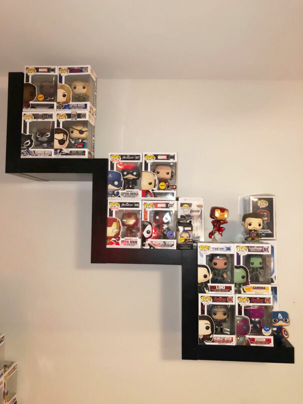 Unpacked Marvel Funko Pop collection displayed on zigzag shelf