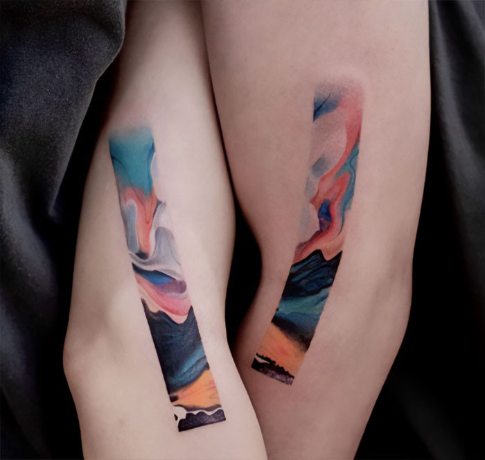 Watercolor landscape elbow tattoo
