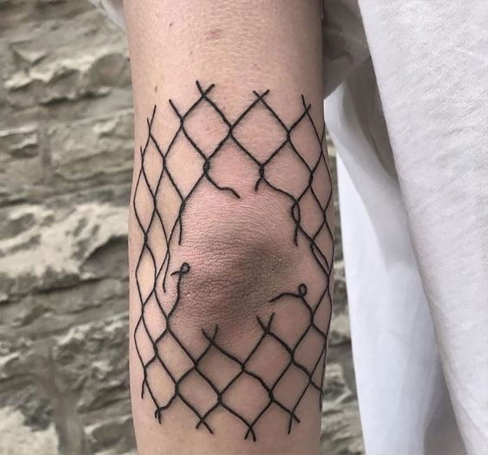 Broken fence elbow tattoo