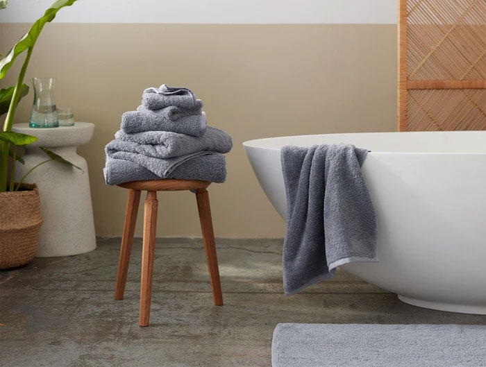 Blue Towels Next To The Bathtub On A Chair