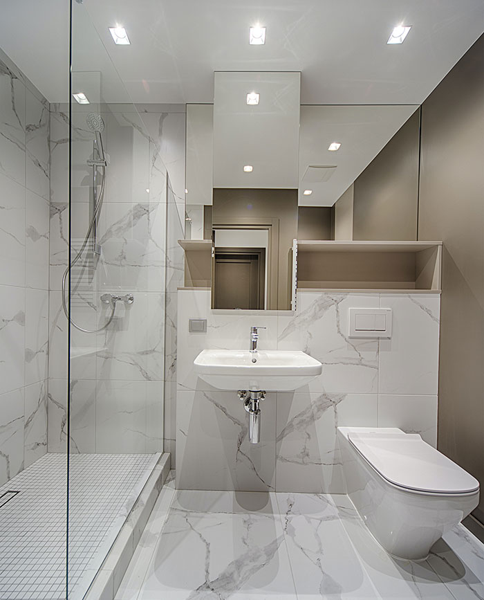 All White Bathroom With Marbled Floor And Walls