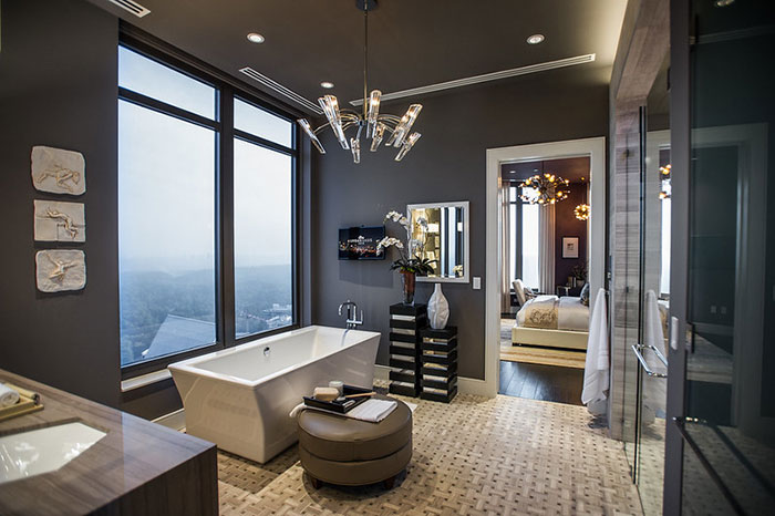 Luxurious Looking Gray Bathroom With A Chadalier In The Middle Of The Bathroom