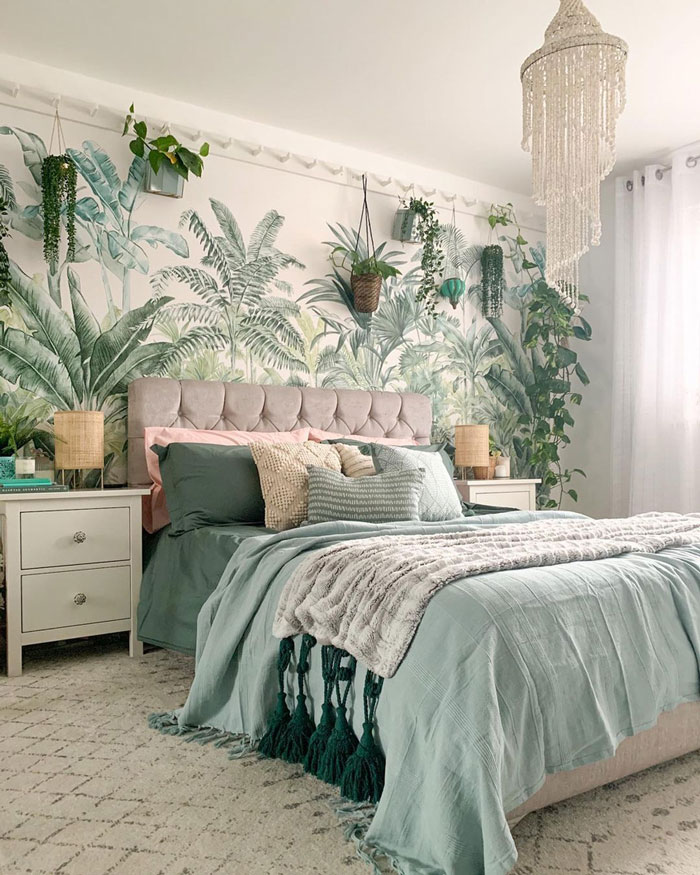 Nature themed bedroom with floral wallpapers, ight green bedding and flowers all around