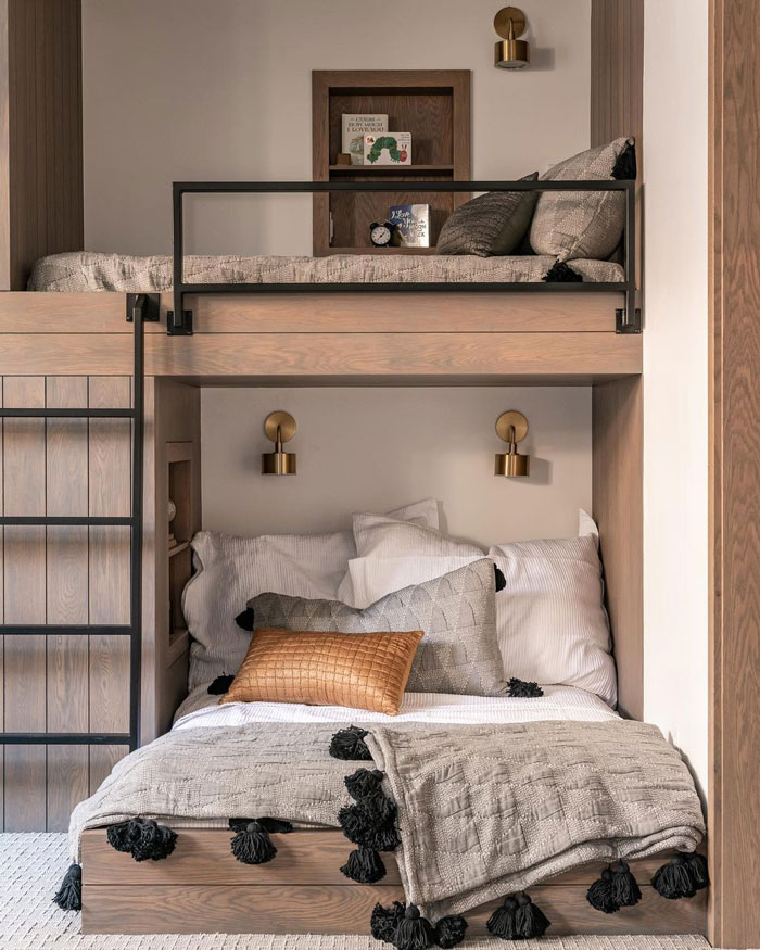 A small bedroom with artsy and cozy bunk bed with gray bedding and white walls
